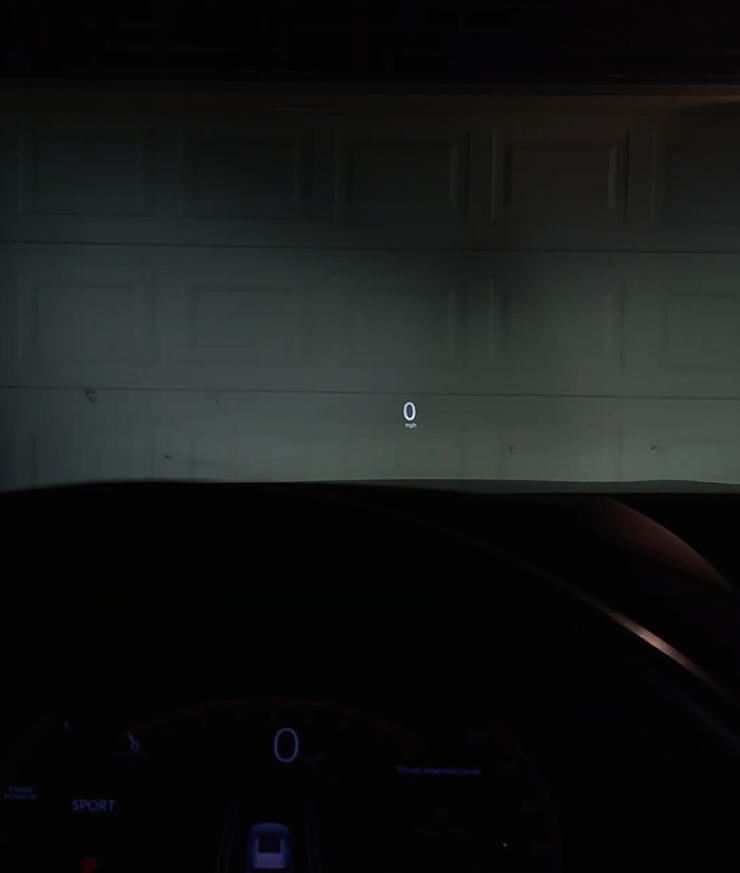 Acura MDX HUD as seen through the windshield in low light, showing minimal 0 mph readout